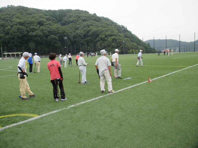 ダイセル播磨光都サッカー場の人工芝の上でグラウンド・ゴルフ競技を行う宍粟市グラウンド・ゴルフ協会の会員ら